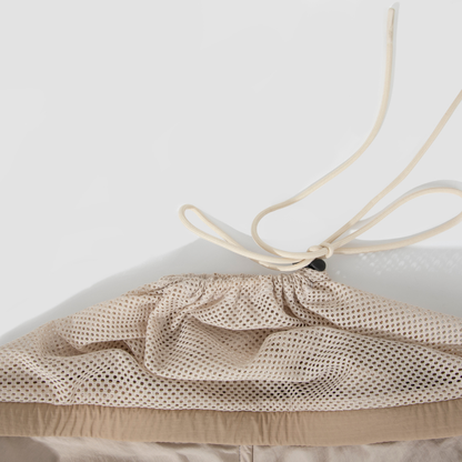 Drawstring closure detail on beige mesh pet sling carrier
