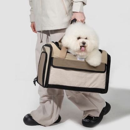White dog riding in beige airline approved foldable pet carrier by owner