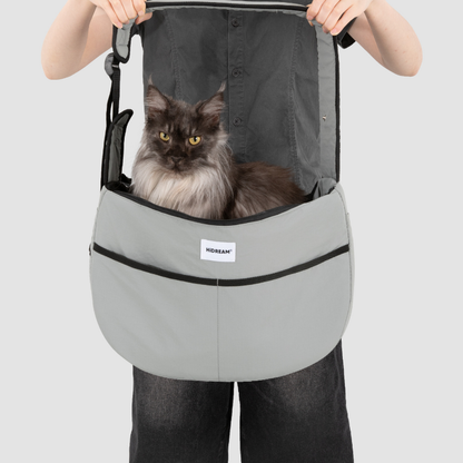 Owner holding black cat in gray outdoor pet tote shoulder bag