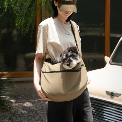 Owner carrying olive outdoor pet tote shoulder bag with small dog