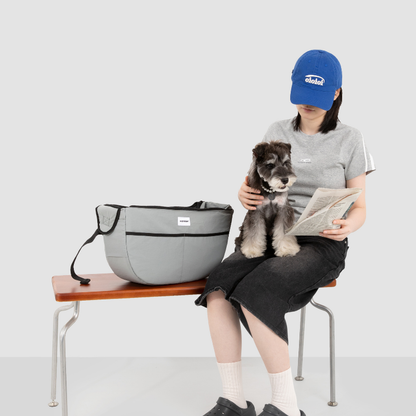 Owner seated with dog in gray outdoor pet tote shoulder bag