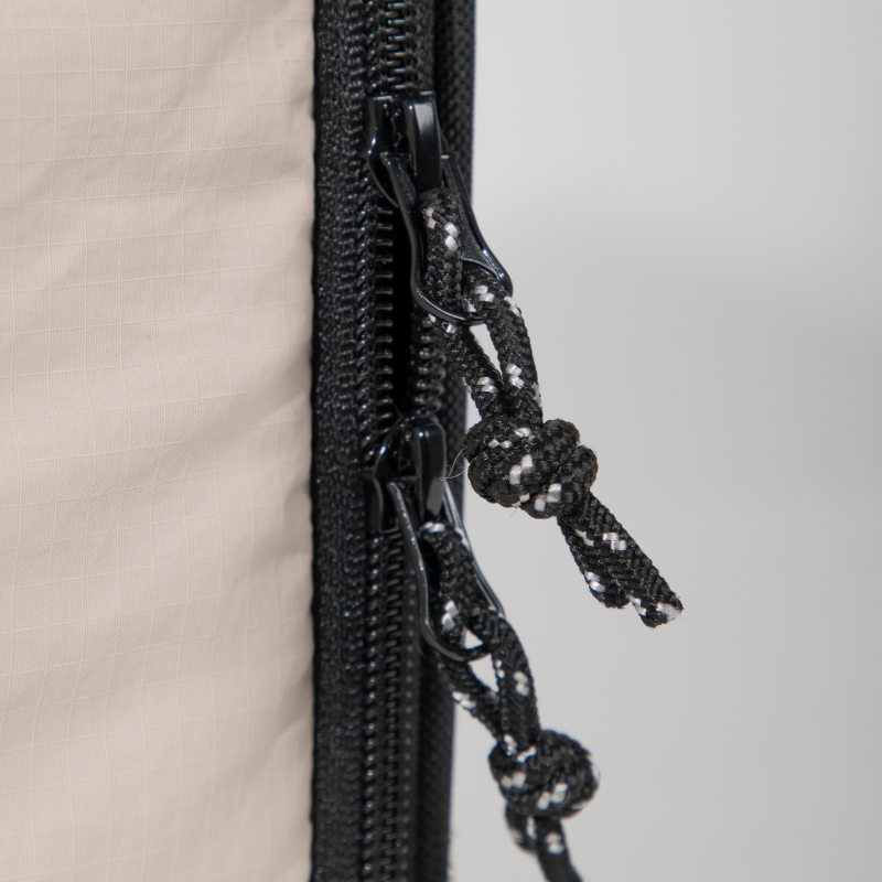 Close-up of zipper pulls on beige airline approved foldable pet carrier