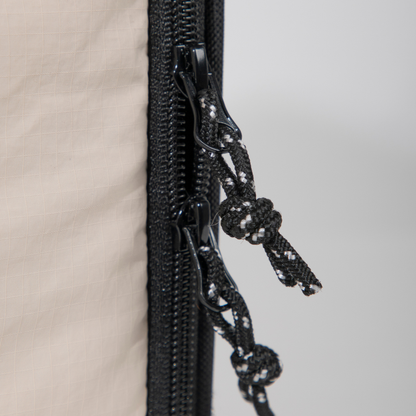 Close-up of zipper pulls on beige airline approved foldable pet carrier