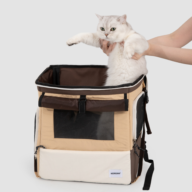 Beiger Haustier-Rucksackträger, bei dem eine weiße Katze durch die obere Öffnung eingesetzt wird