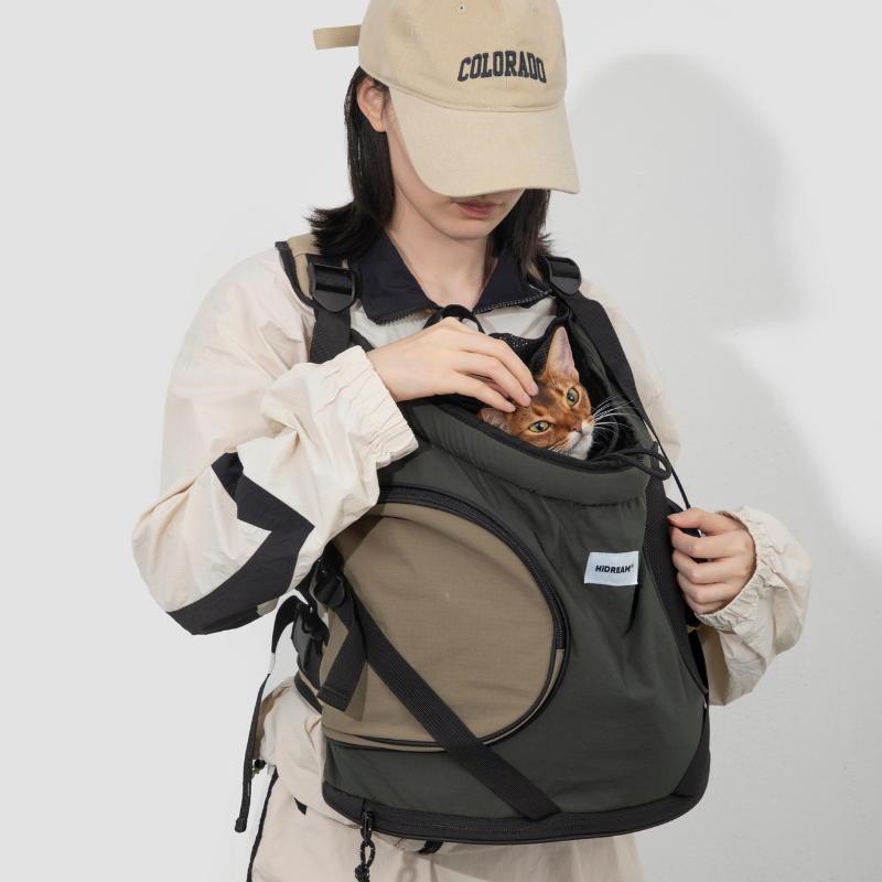 Cat in dark green front-facing carrier backpack with drawstring opening