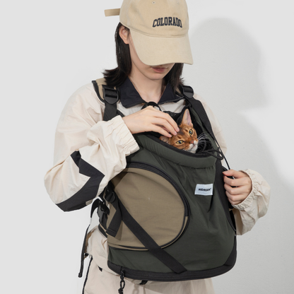 Cat in dark green front-facing carrier backpack with drawstring opening