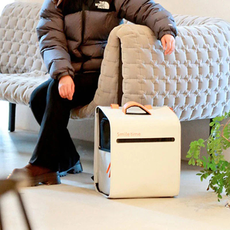 Weißer Smiletime Katzentragerucksack mit gepolstertem Innenraum, neben einem Sofa gezeigt