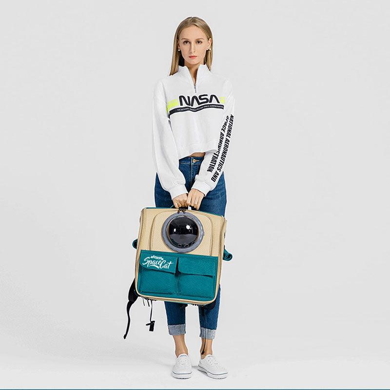 Model steht mit beige-türkisem SpaceCat-Rucksack, Vorderansicht