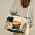 Gray wheeled cat carrier shoulder bag with white cat inside