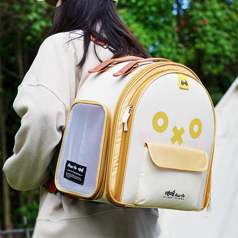 Person, die einen gelben Katzen-Rucksack mit Cartoon-Gesichtstasche trägt