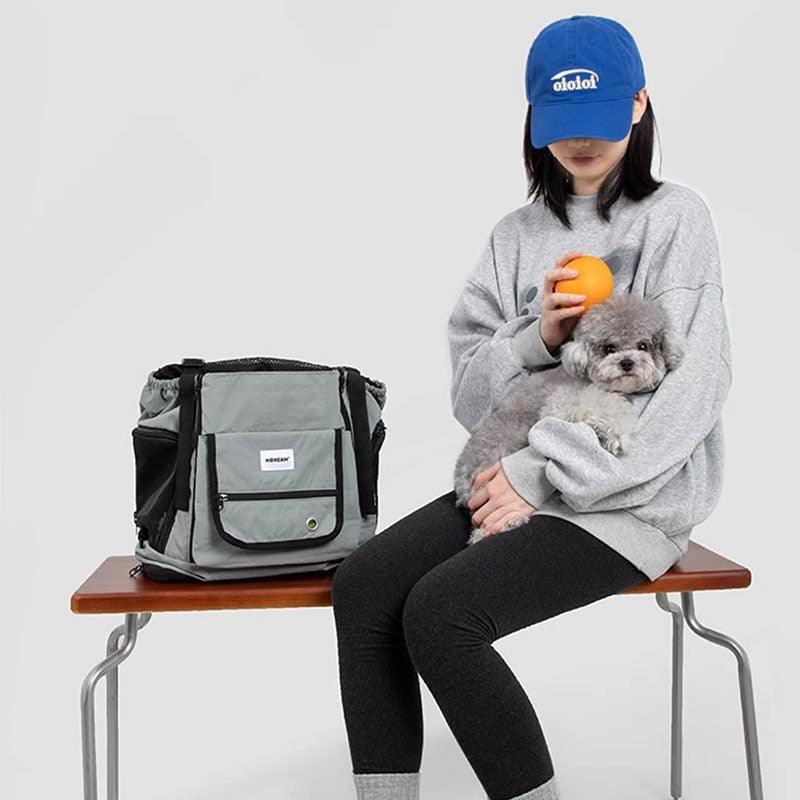 Hellblauer Brustträger-Rucksack neben sitzender Person mit Hund
