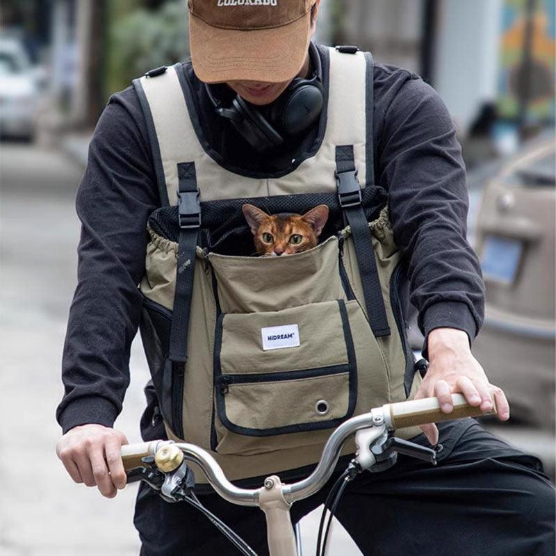 Person beim Radfahren mit Hund im beigen Brustträger-Rucksack