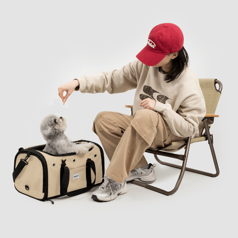 Beige Toast-Stil Haustier-Tragetasche für Flugreisen neben sitzendem Besitzer, der grauen Hund streichelt