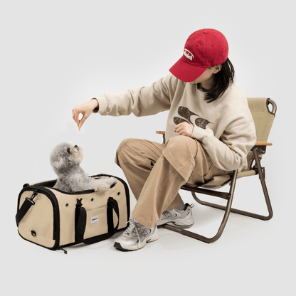 Beige Toast-Stil Haustier-Tragetasche für Flugreisen neben sitzendem Besitzer, der grauen Hund streichelt